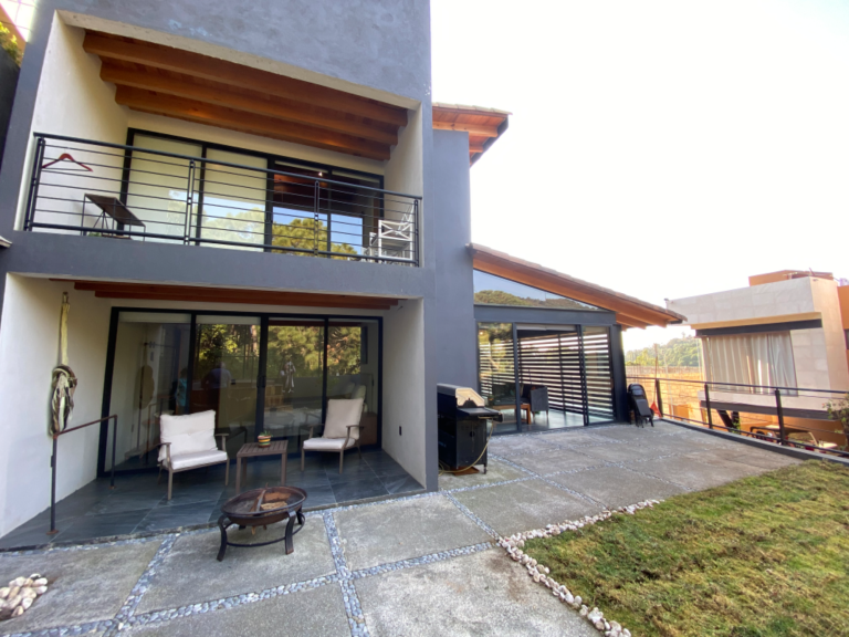 Vista de la casa del jardín de atrás de la casa con asador y firepit Vista de la casa del jardín de atrás de la casa con asador y firepit